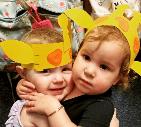 Children at day care with giraffe hats they made